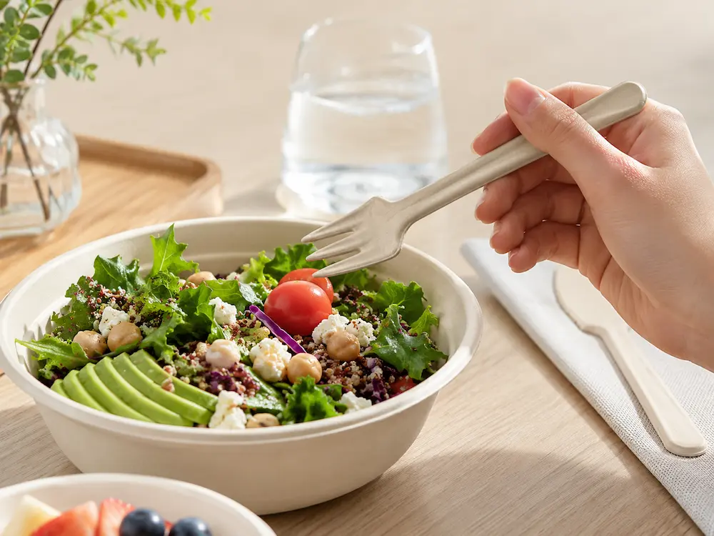 Natural-color 6-Inch Molded Fiber Fork used with a fresh salad containing lettuce, avocado, tomatoes, chickpeas, grains, and cheese