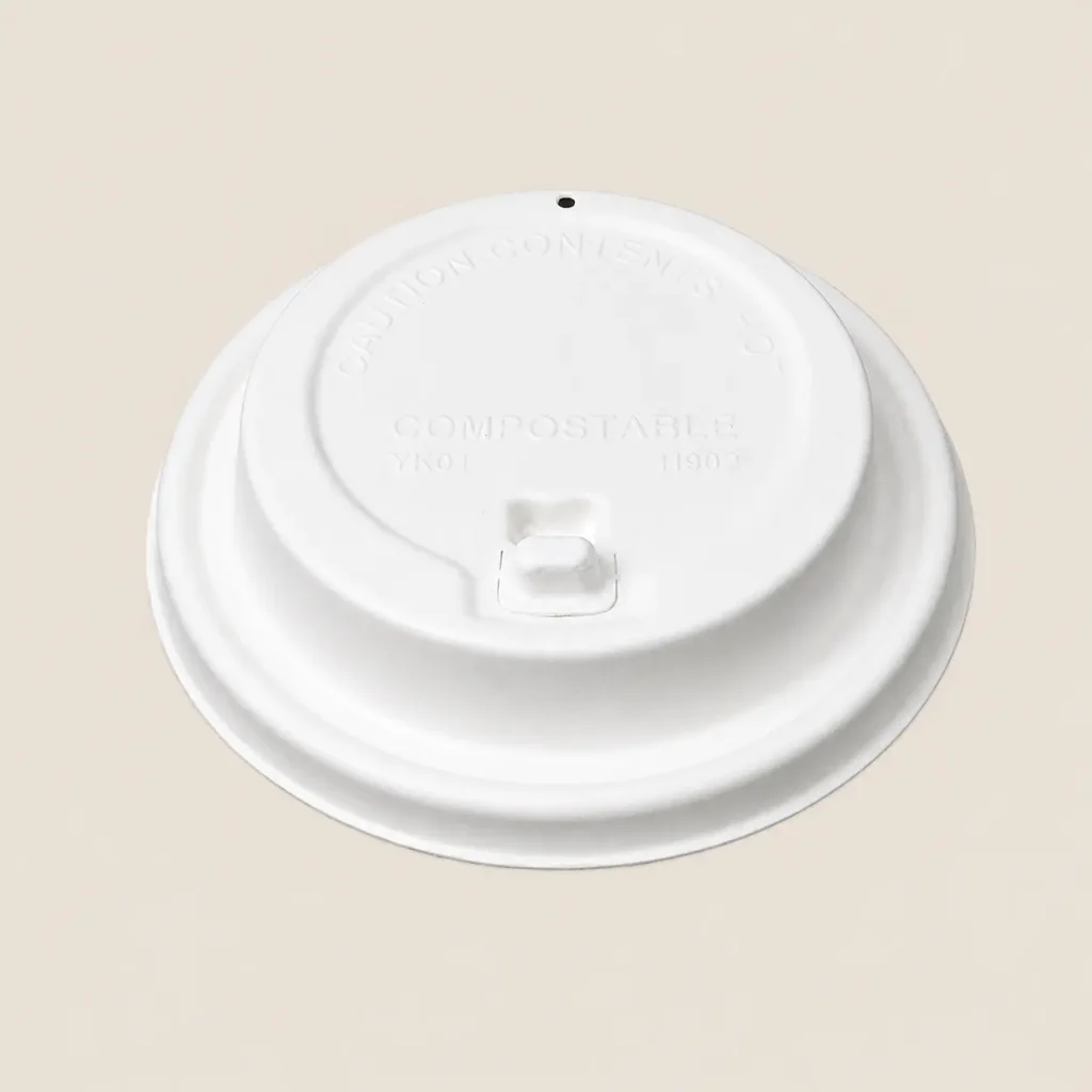 Front angled view of a white 90mm flip-top molded fiber hot cup lid with the drinking tab closed and a separate vent hole