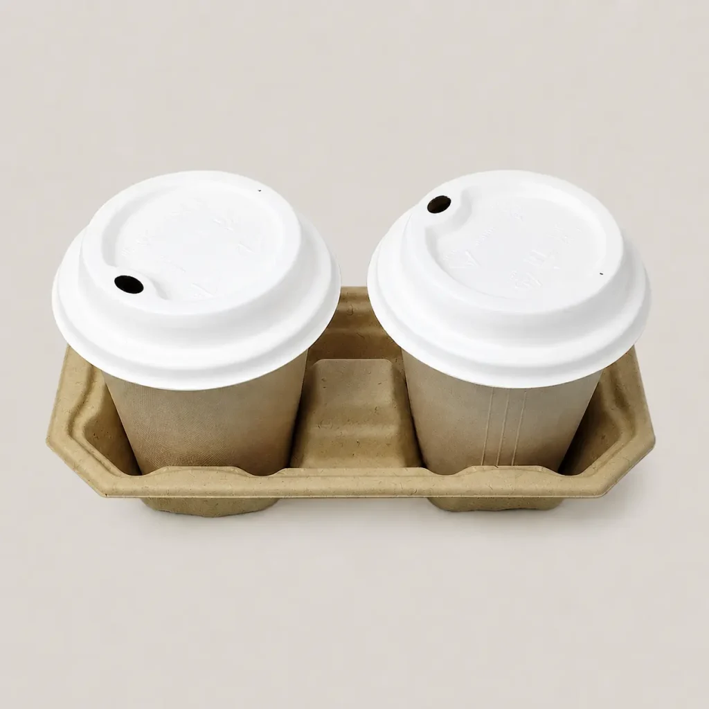 Two takeaway cups fitted with white 90mm molded fiber hot cup sip lids in a molded fiber two-cup drink carrier